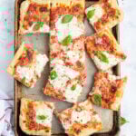 Italian Focaccia flatbread made into a Margherita pizza with mozzarella and a light marinara sauce.