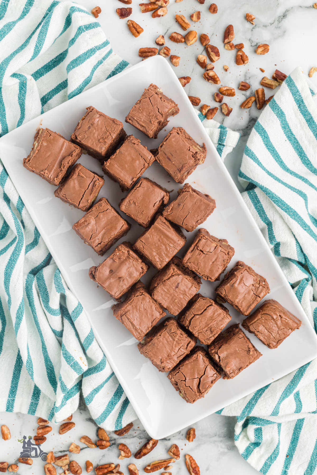 A white candy dish filled with Million Dollar Fudge squares. 