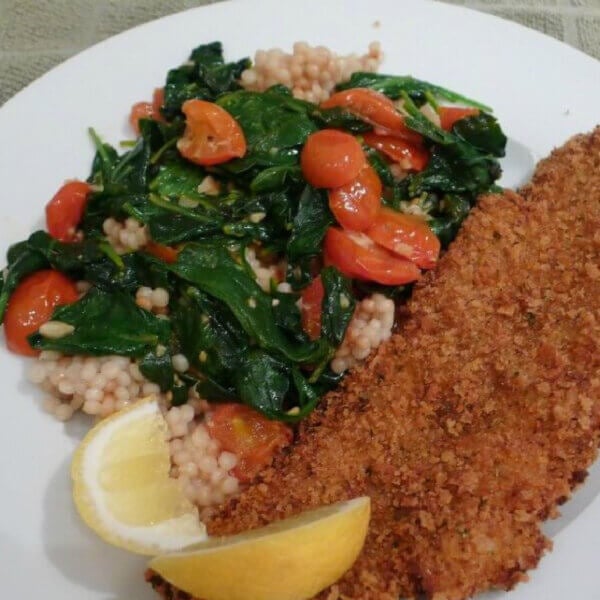 Sauteed fresh baby spinach with grape tomatoes served with crispy, black drum a fish that's light, tasty, not oily.