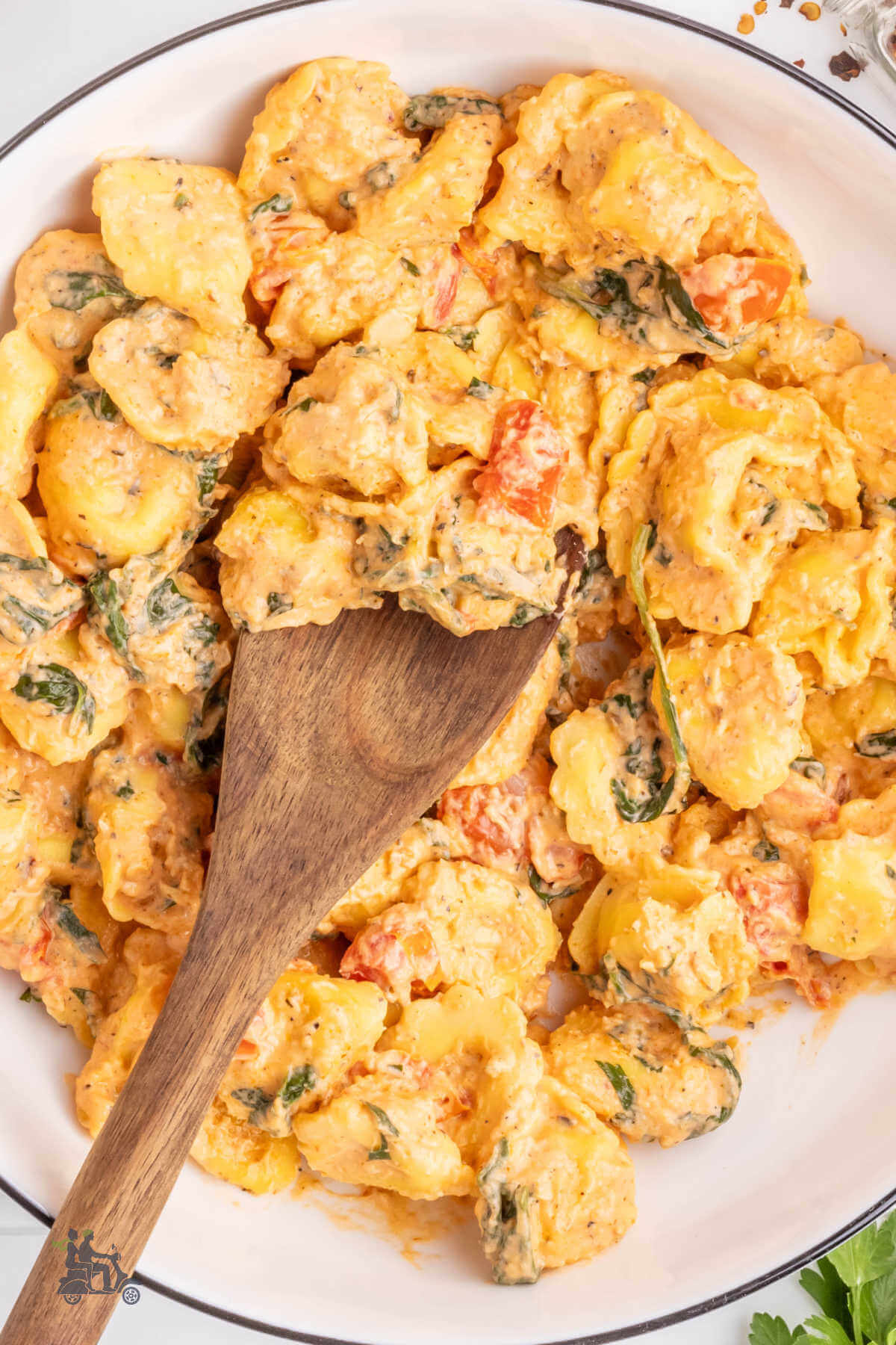 Cheese tortellini pasta drenched in a creamy garlicky sauce with tomatoes and spinach. 
