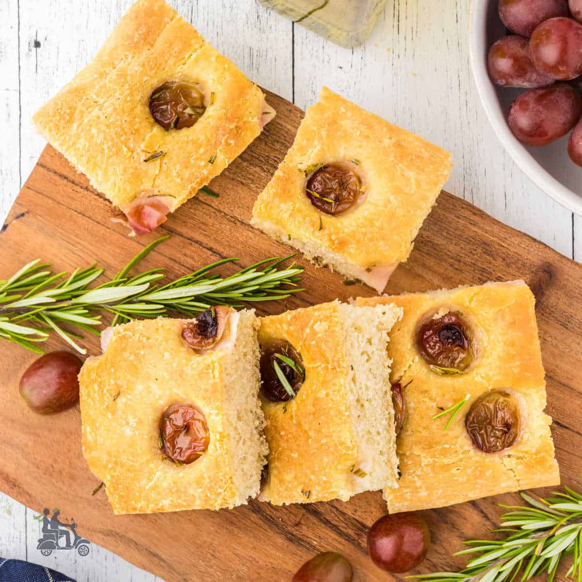 Squares of Sourdough focaccia topped with concord grapes and rosemary.