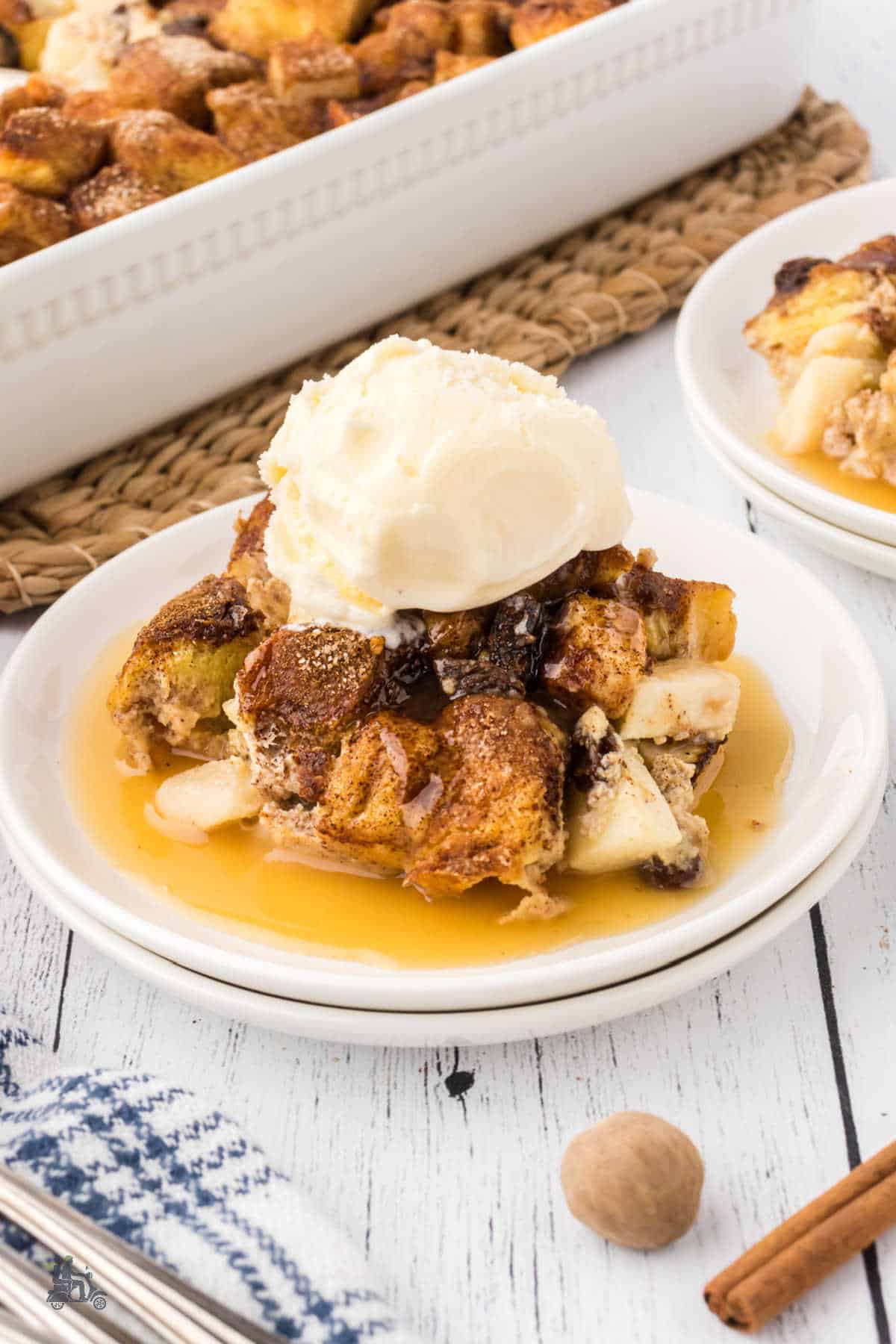 Bread Pudding dessert with a dollop of vanilla ice cream on top and a drizzle of caramel bourbon sauce over the dessert to finish it off. 