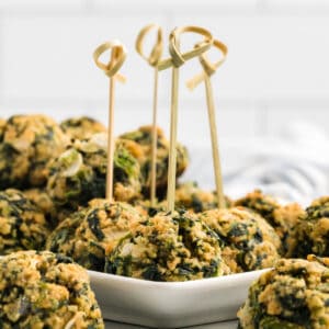Spinach Cheese Appetizer Balls with bamboo skewers piercing them.