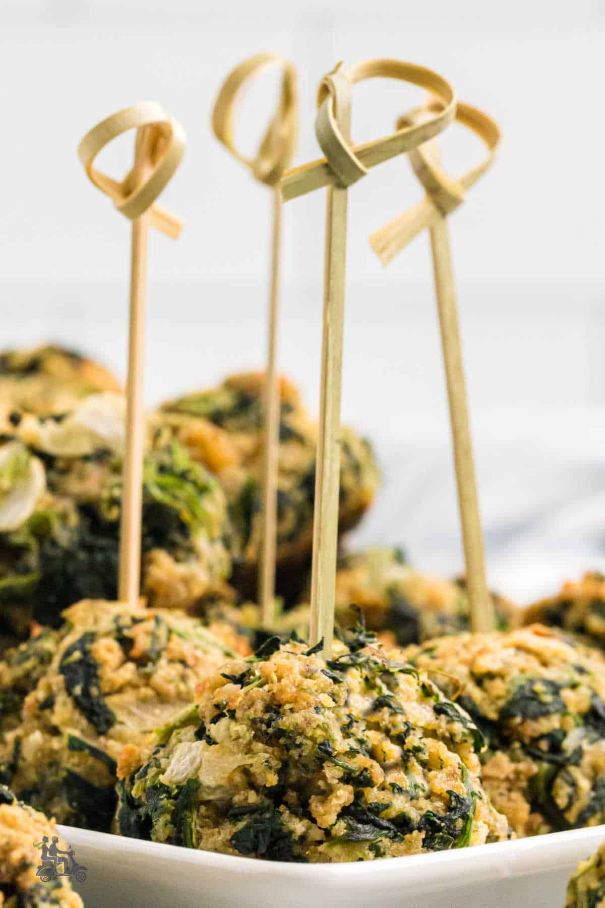 Closeup of Parmesan Spinach Balls with bamboo skewer servers. 