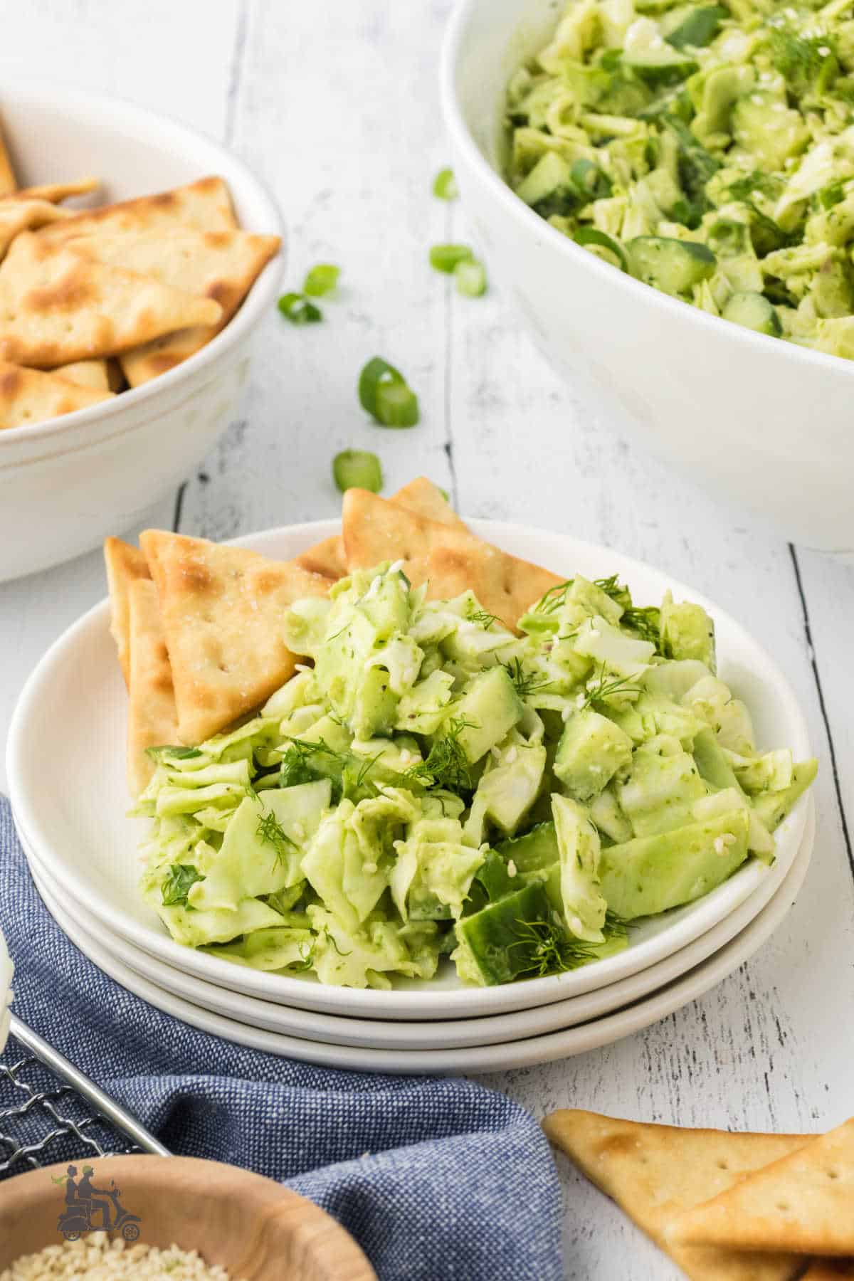Green Goddess Salad with dressing on a white plate with pita chips on the side. 