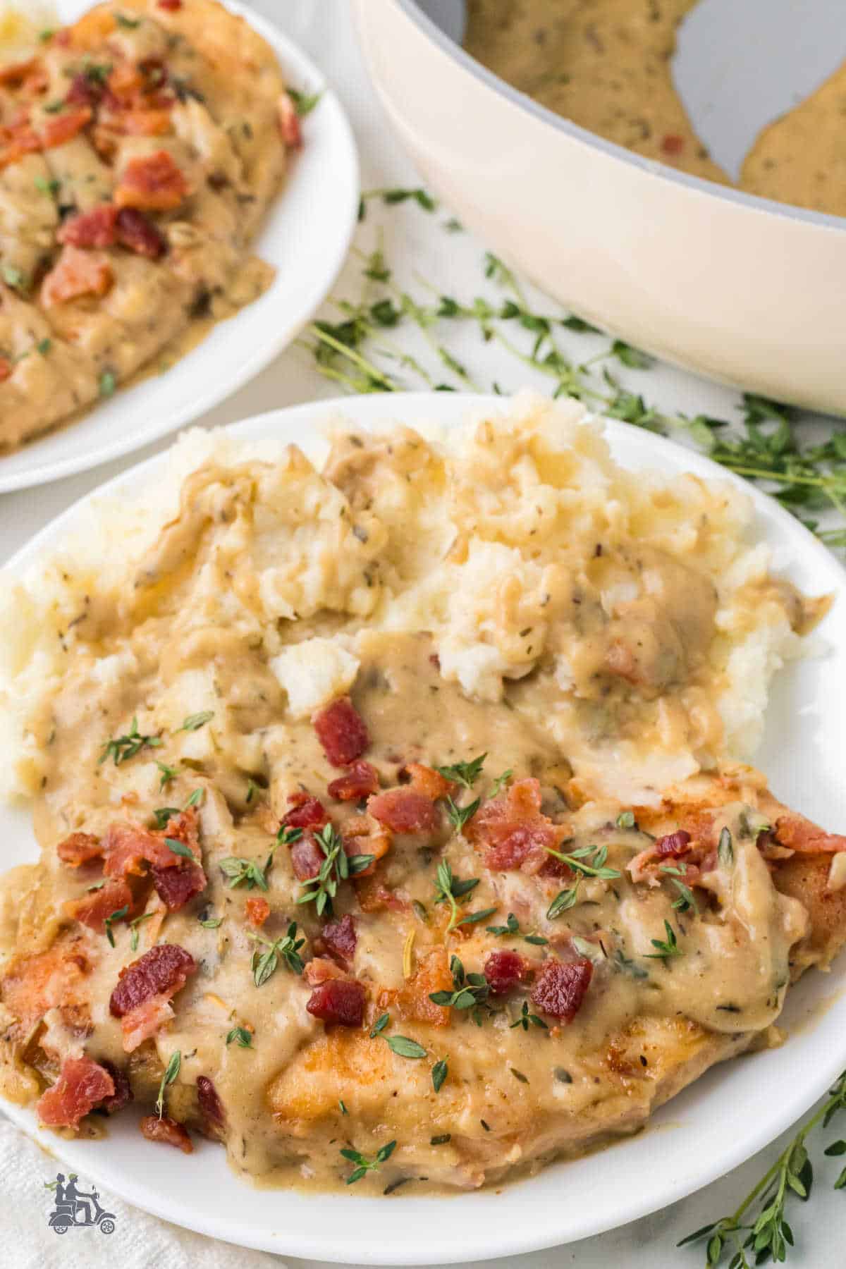 Chicken smothered in a creamy white gravy with crispy bacon sprinkled on top.