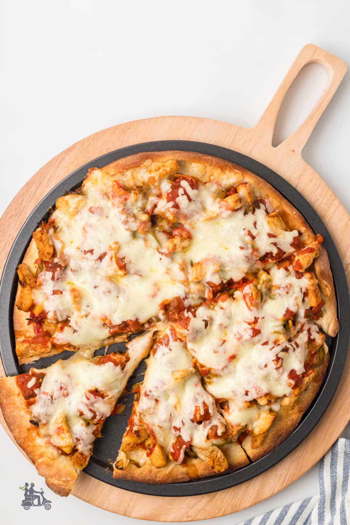 A baked Chicken Fajita Pizza on a wooden serving board, sliced and ready to serve. 
