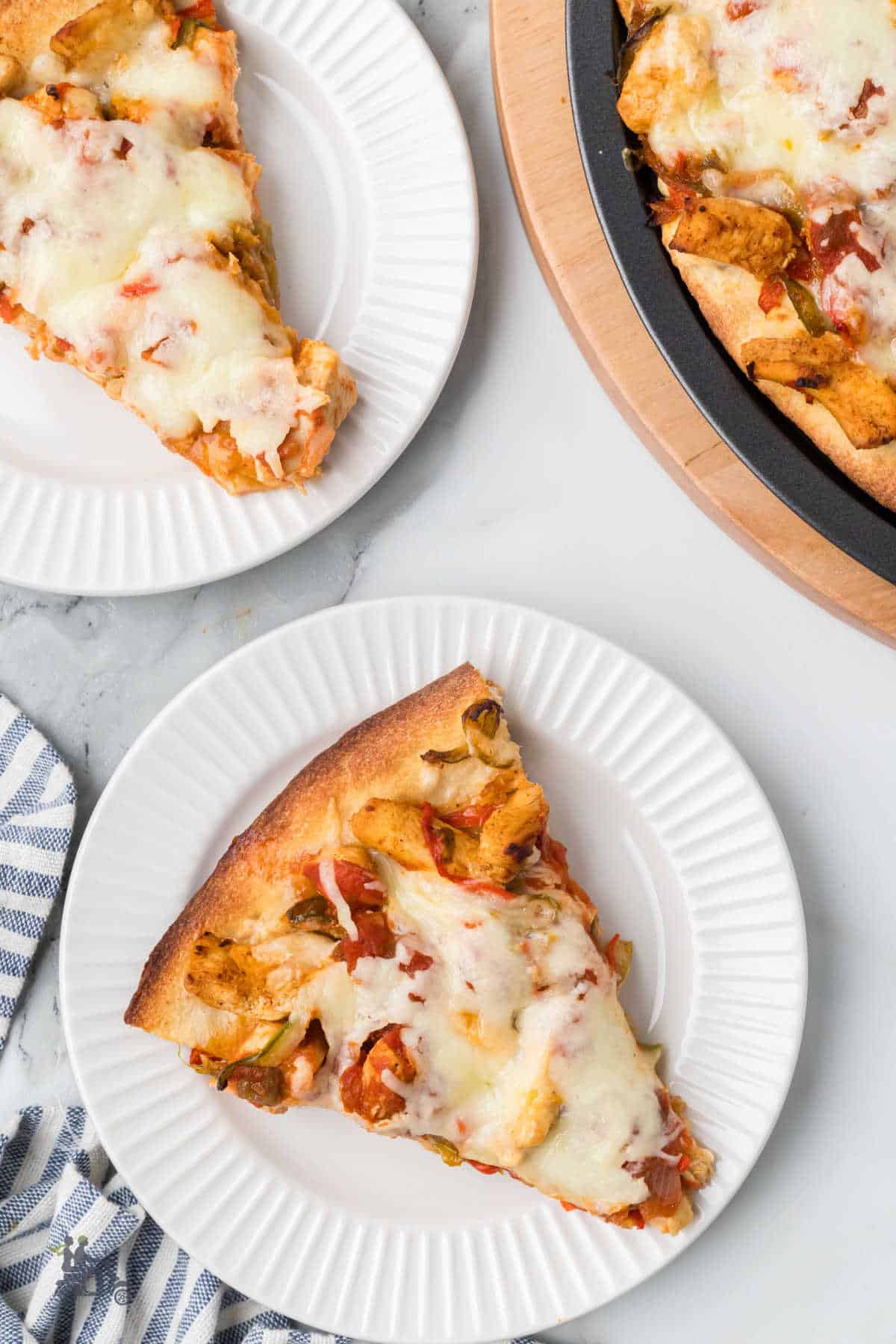 Mexican pizza slices are on white plates and are ready to enjoy. 