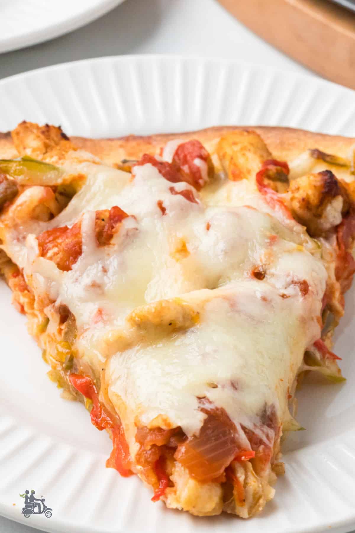 A close-up of a cheesy Mexican chicken fajita pizza slice. 