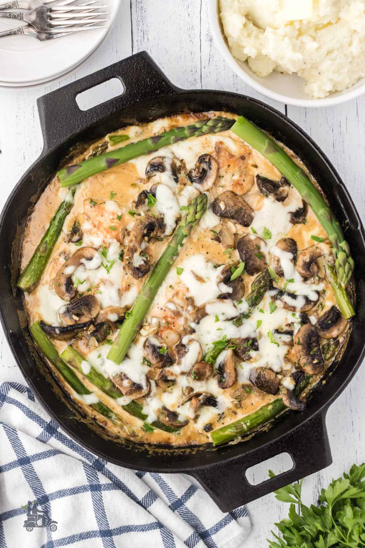 One-skillet cooked chicken breasts in savory gravy with asparagus spears. 