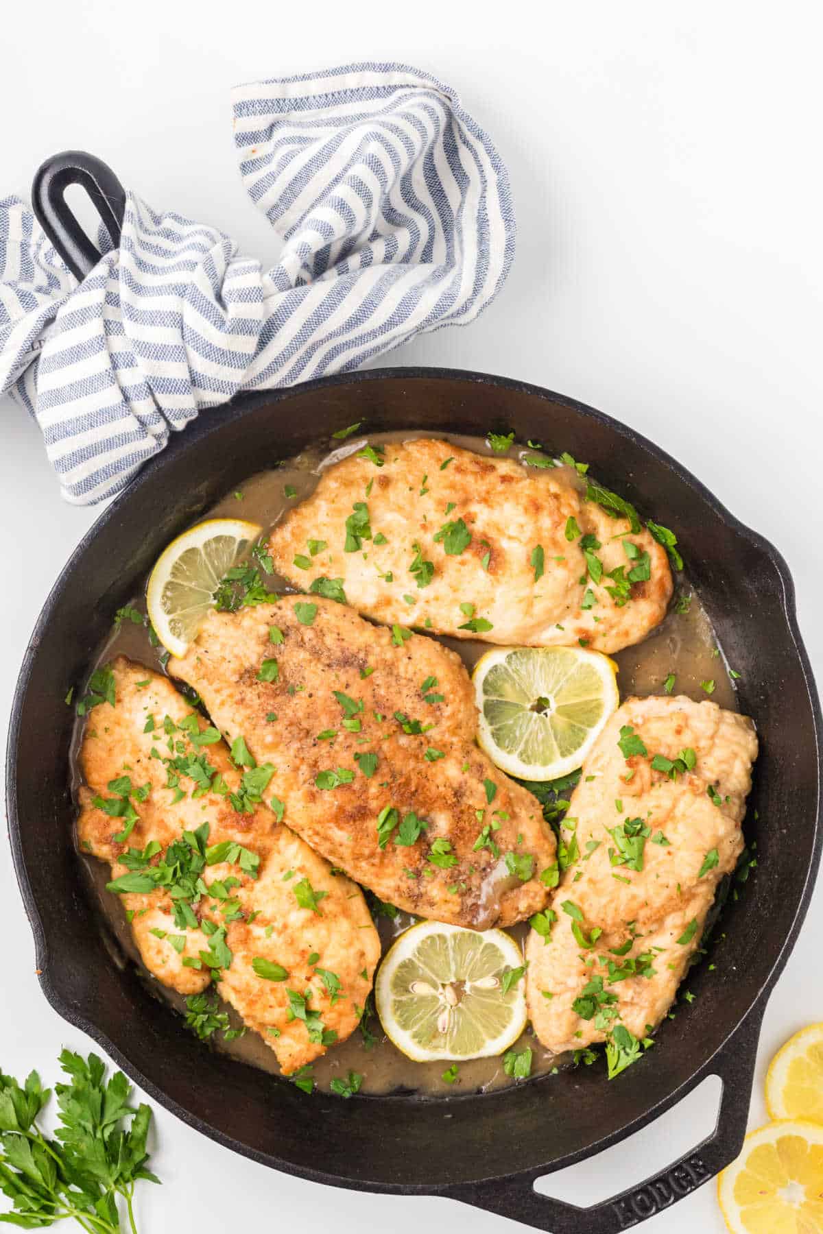 One-skillet chicken cutlet dinner in lemon sauce with parsley garnish. 