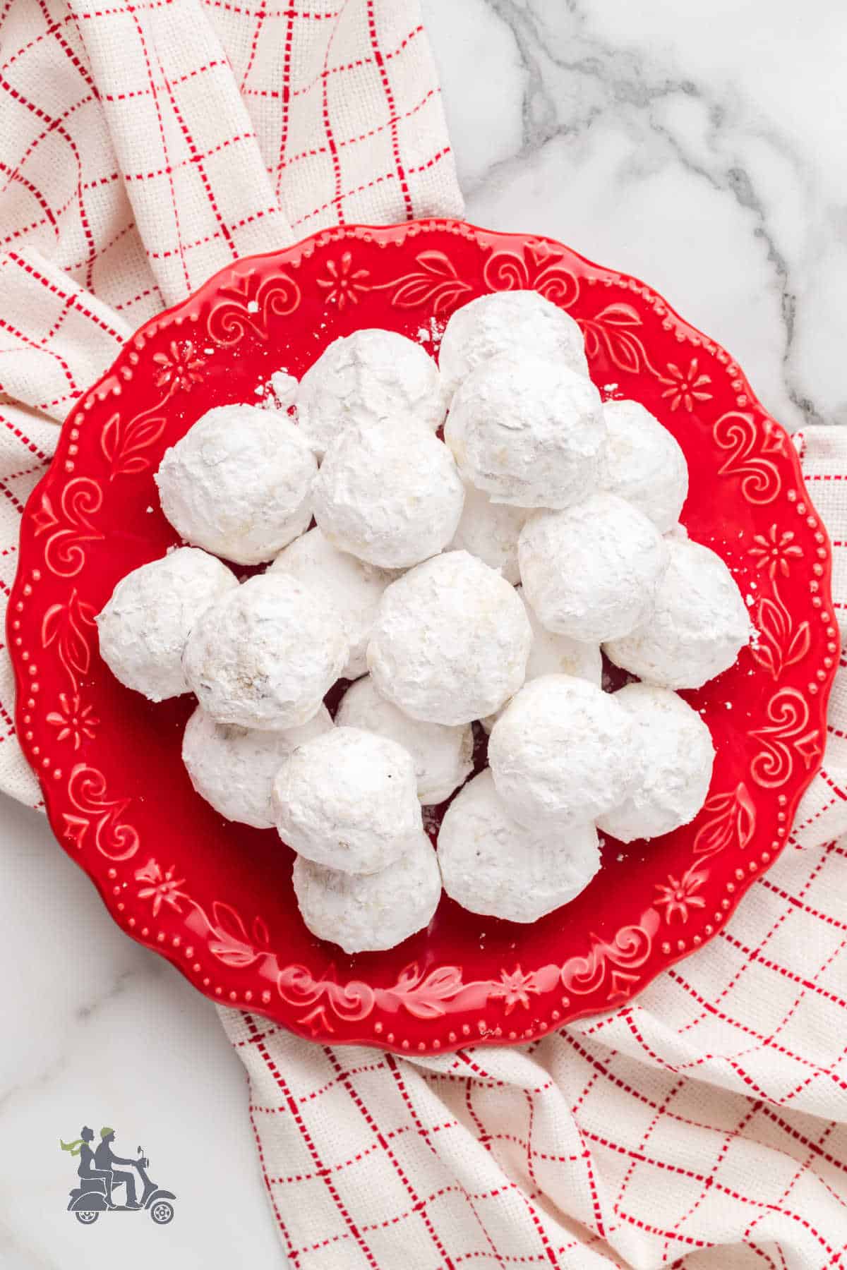 The red serving bowl holds Italian Snowball cookies.