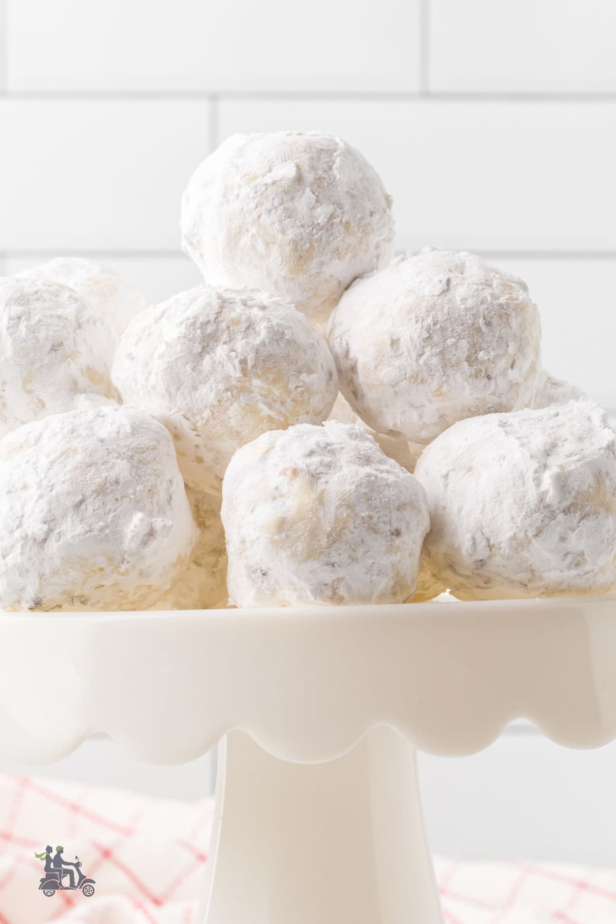 A pedestal cookie server piled high with a pyramid of Italian Wedding Cookies. 