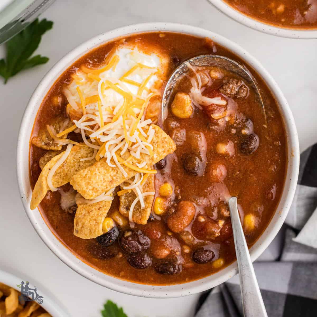 Bowl of Slow Cooker Taco Soup Topped With sour cream and corn chips.