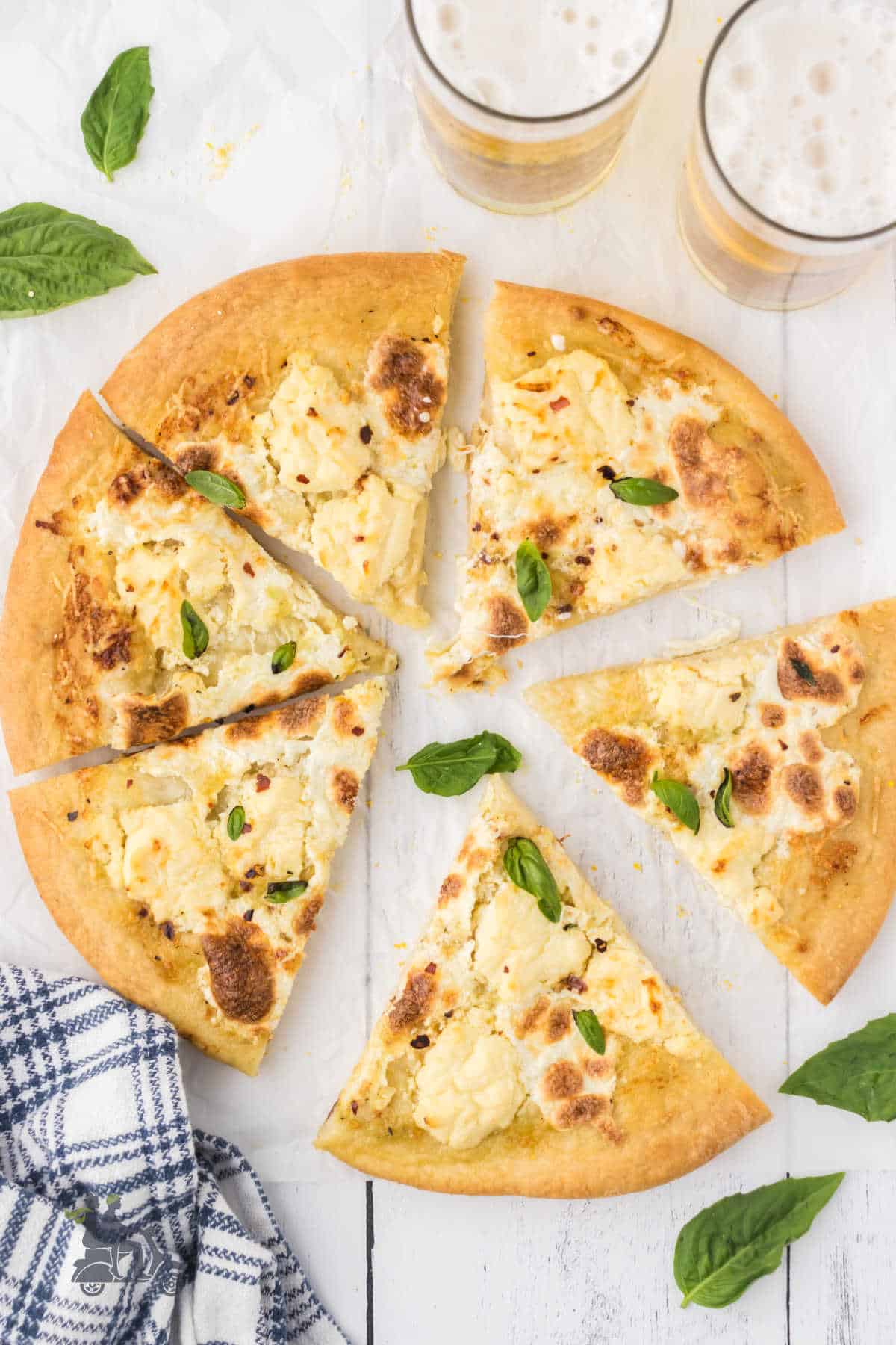 A round pizza with olive oil and three cheese toppings cooked and sliced into eight wedges. 