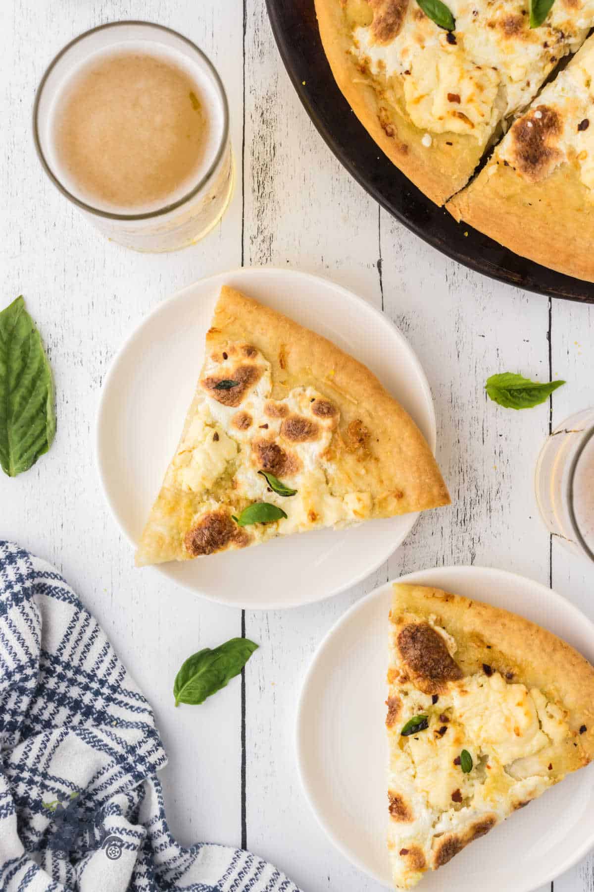 Overhead view or two plates with white pizza slices on them. 