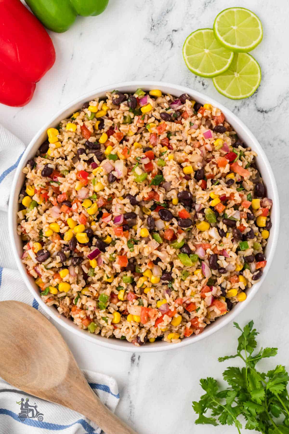 A large white serving bowl filled with rice salad with tuna and a Southwestern flavor. 