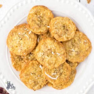 A white plate stacked with coconut cookies made with bran flakes.