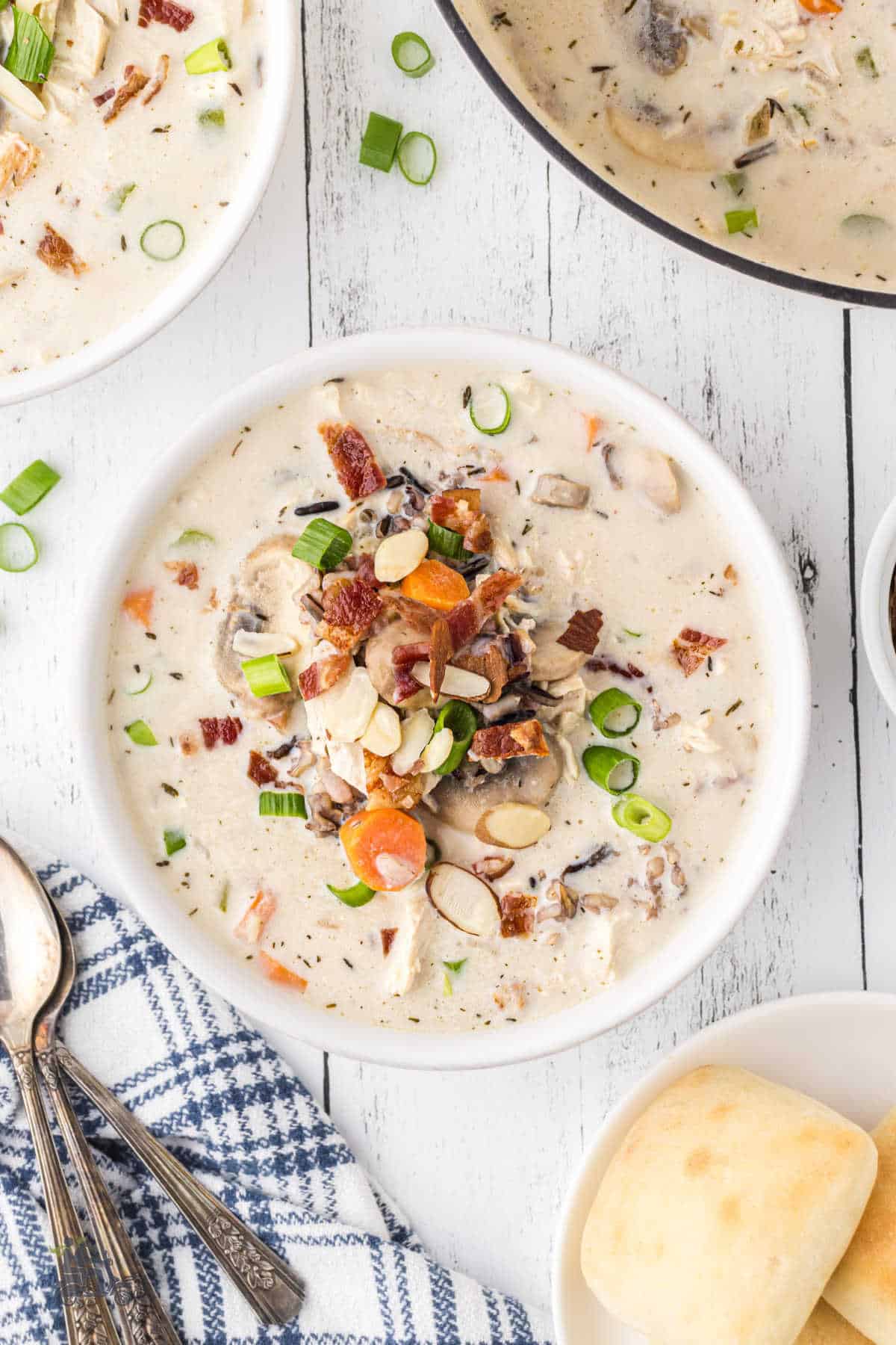 White soup bowl filled with creamy chicken wild rice soup with mushrooms. 