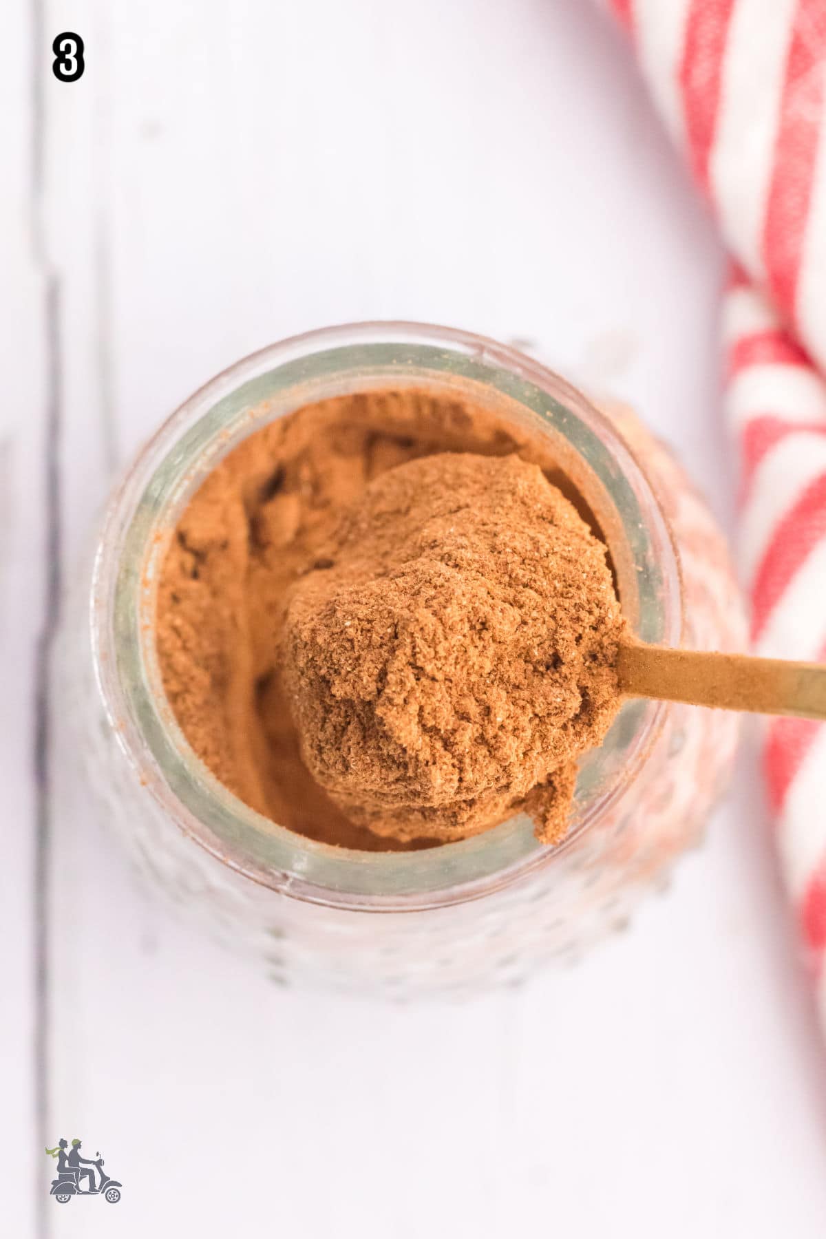 Homemade apple pie spice blend stored in a glass jar.