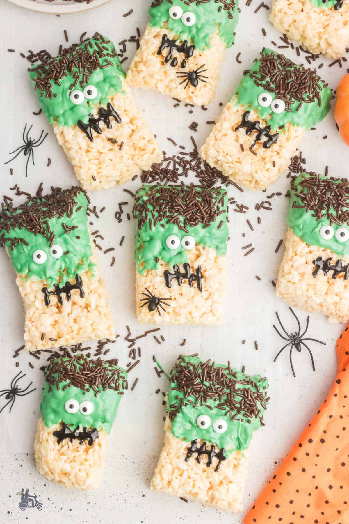 Halloween rice krispie treats in the shape of Frankenstein's heads on a white counter. 