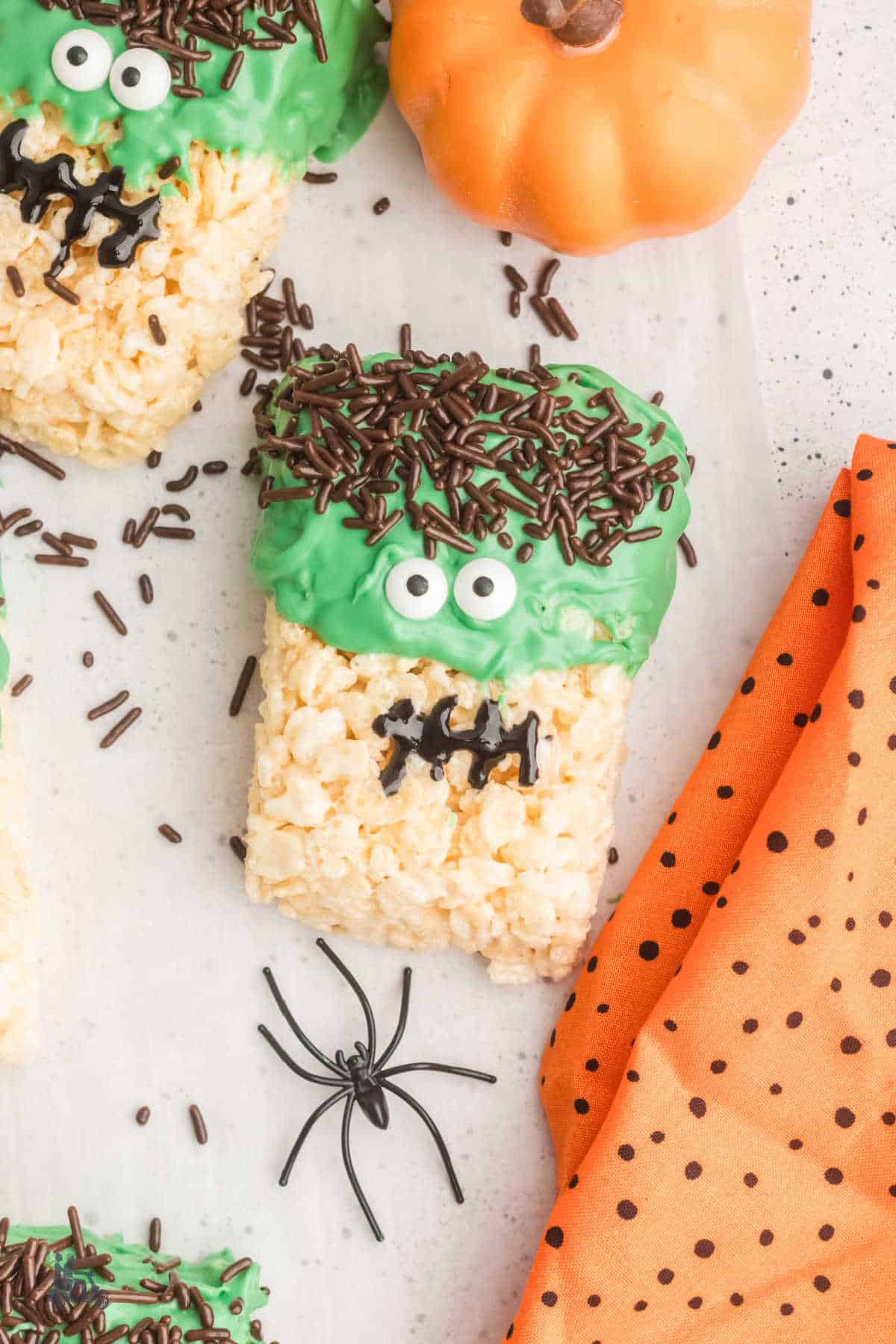 Rice Krispie Frankenstein Halloween treat with a black spider crawling to the dessert bar. 