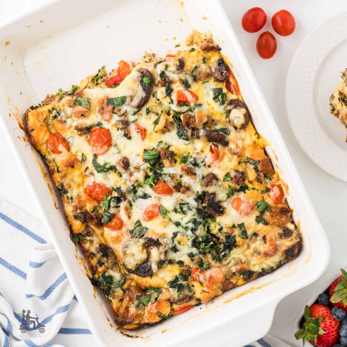 Breakfast strata with sausage in a white casserole dish.