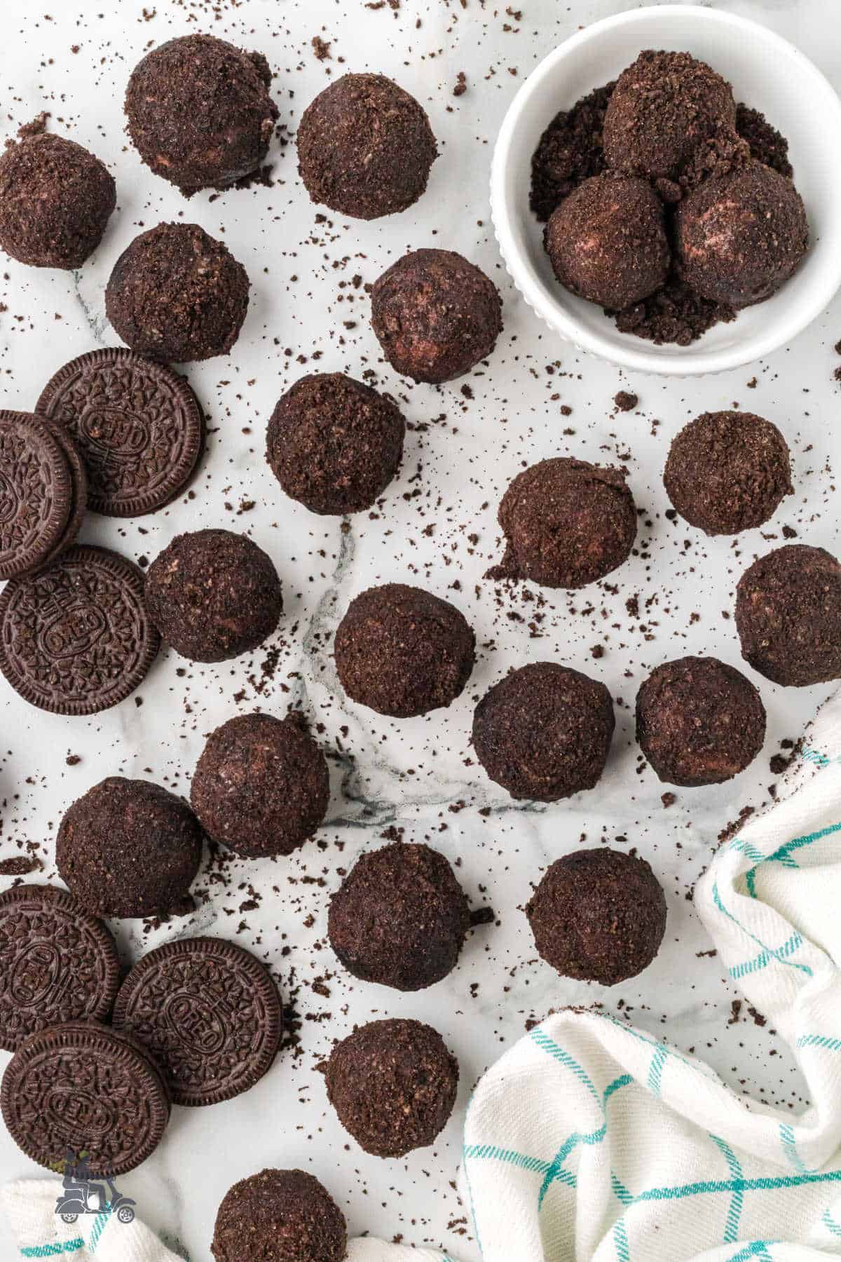 A white counter covered with chocolate truffles made with cream cheese, rum, espresso, and extra Oreo cookies. 