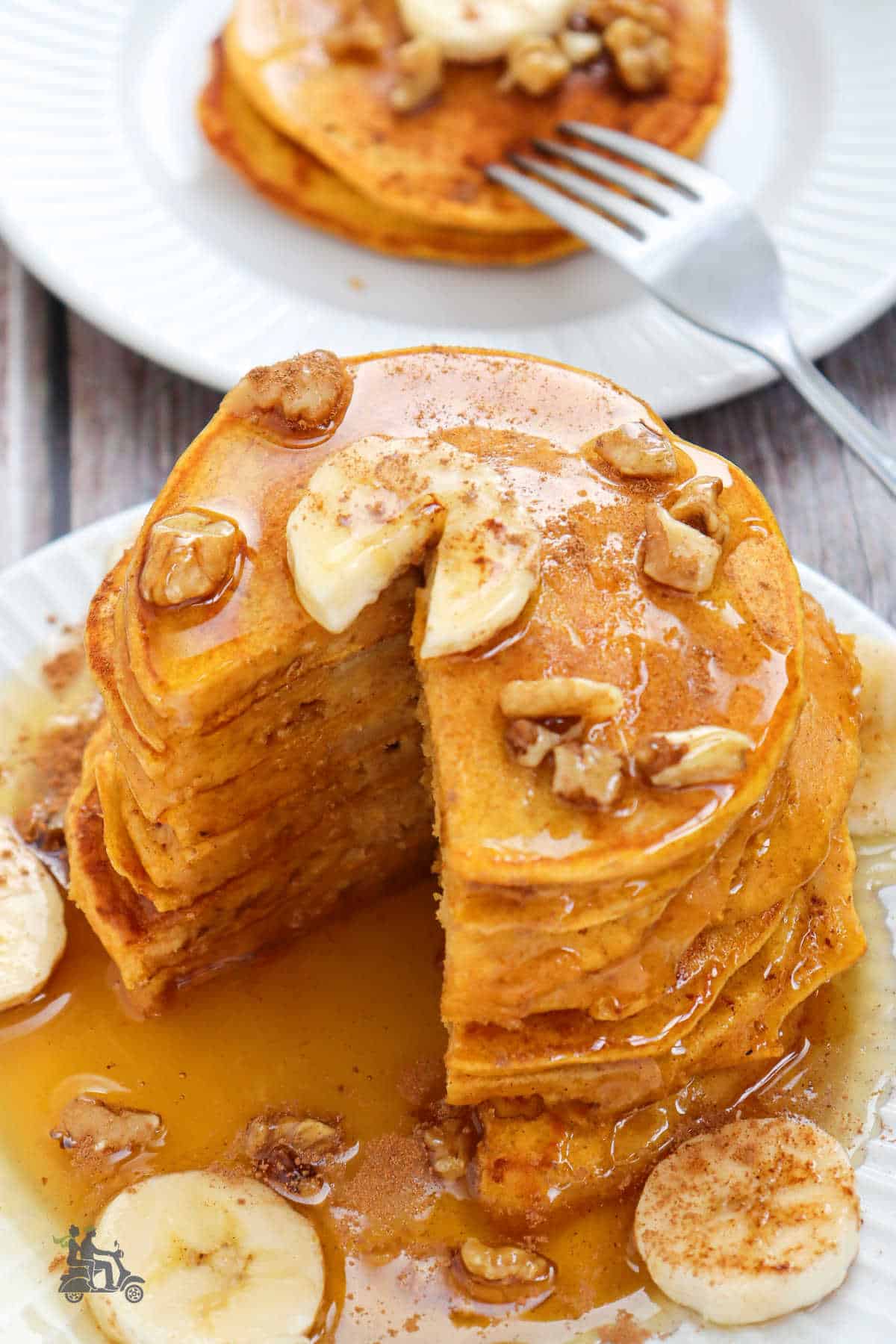 Breakfast pancakes made with pumpkin, bananas, and maple syrup are poured over the breakfast cakes. 