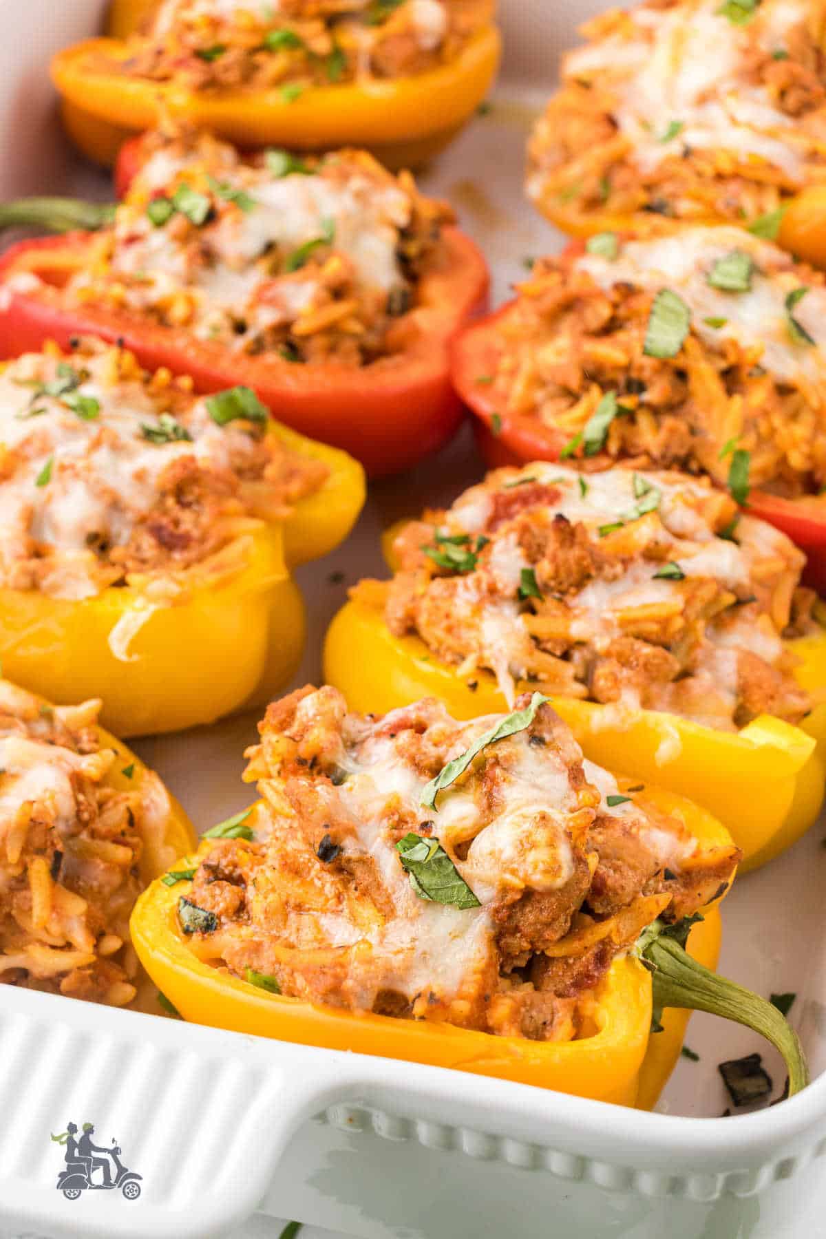 Oven-baked stuffed peppers in a white casserole baking dish. 