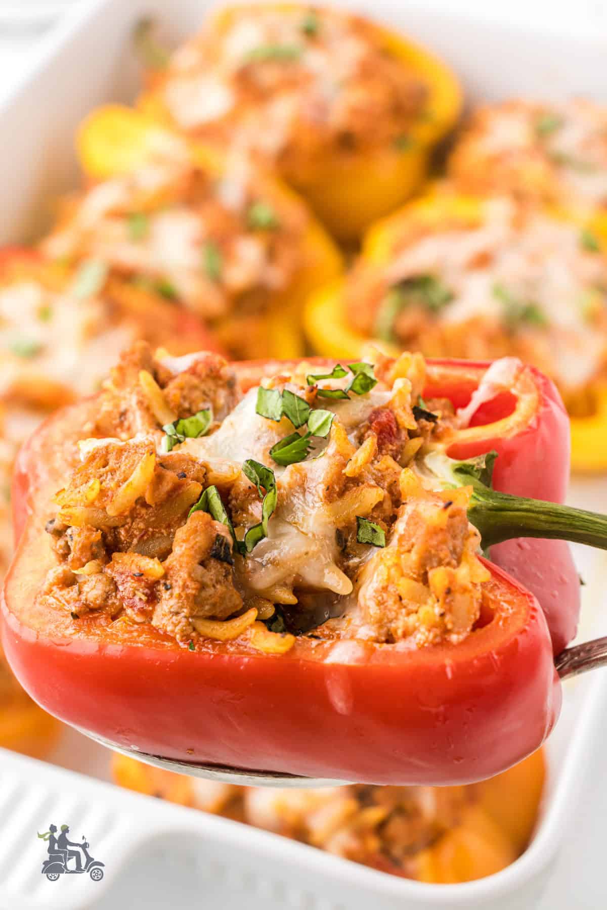 Closeup of a red bell pepper halve stuffed with orzo pasta and ground turkey sausage. 