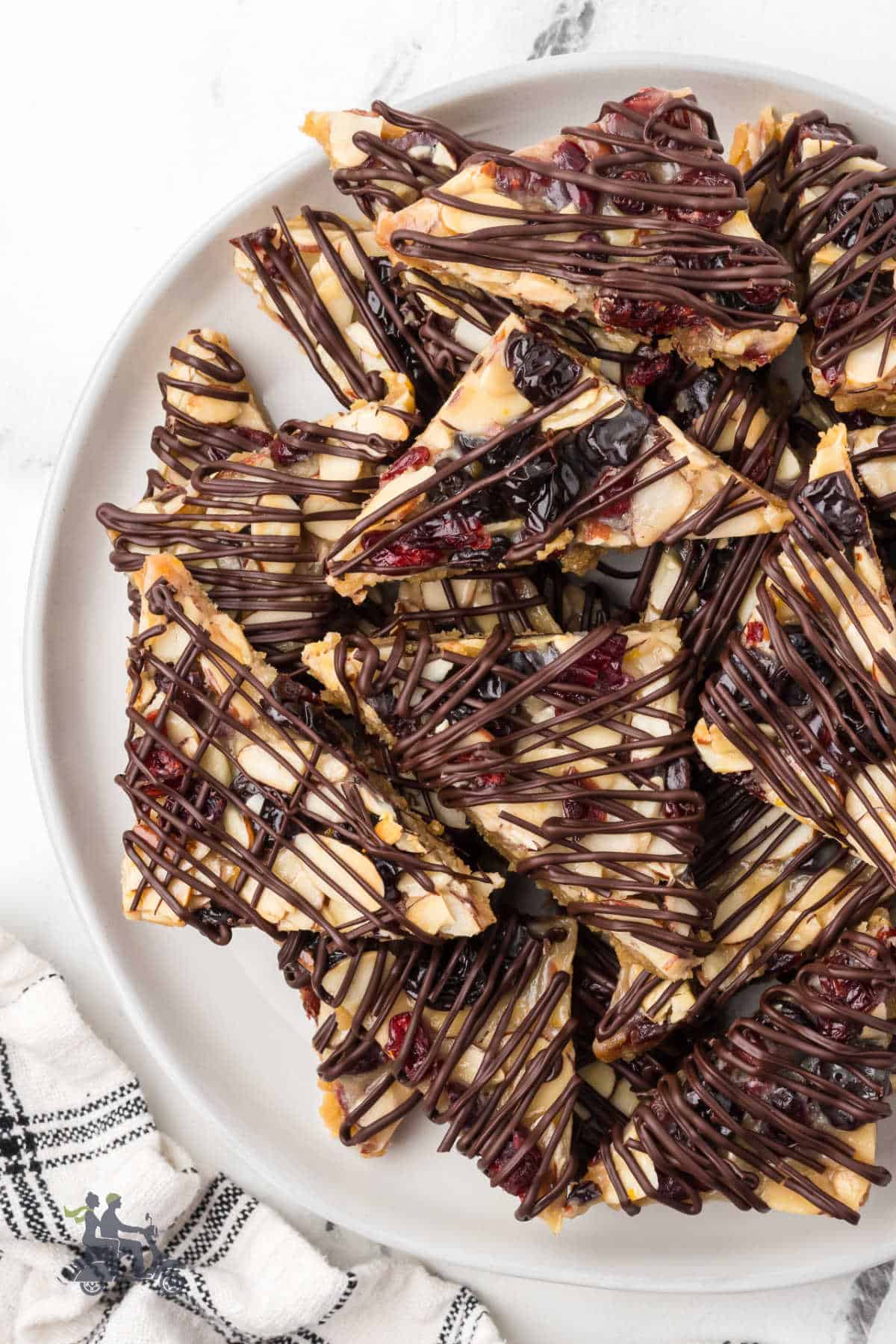 A white dessert plate stacked with the Holiday Italian Florentine cookie studded with nuts and dried fruit. 