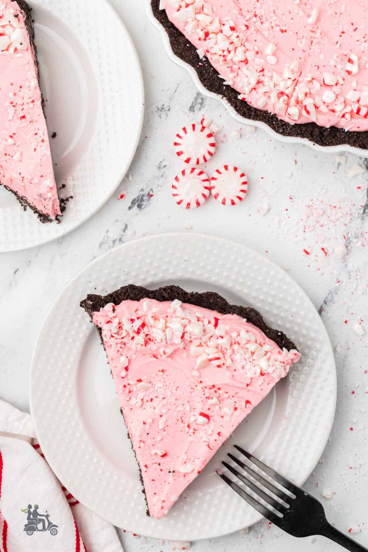 Slices of Frozen Peppermint Pie with oreo crust on a white dessert plate. 