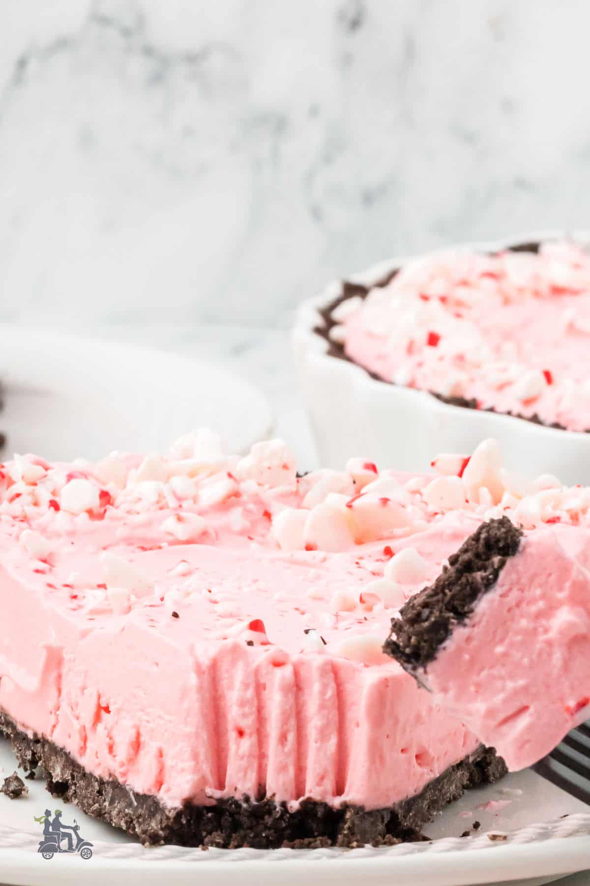 A fork removes a portion of the candy peppermint pie's tip. 