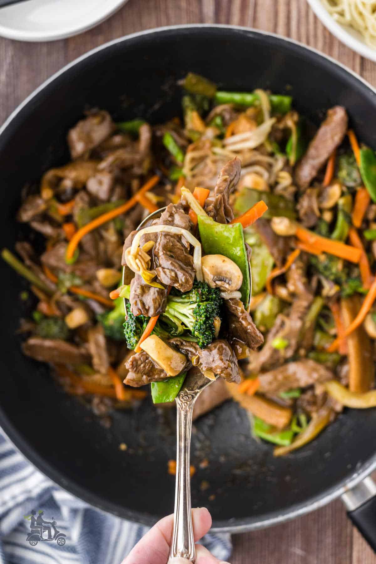 A serving spoon contains a helping of the beef and vegetables from the chop suey recipe.