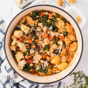 White Dutch oven filled with Italian Bean and Bread Soup with Kale.