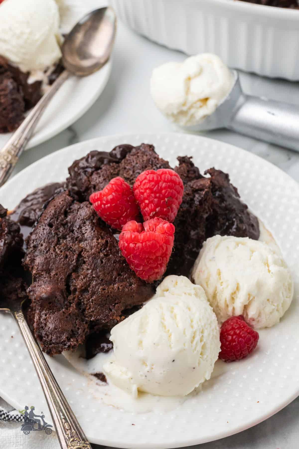 Chocolate amaretto cake with a gooey pudding layer and served with fresh raspberries and vanilla ice cream.