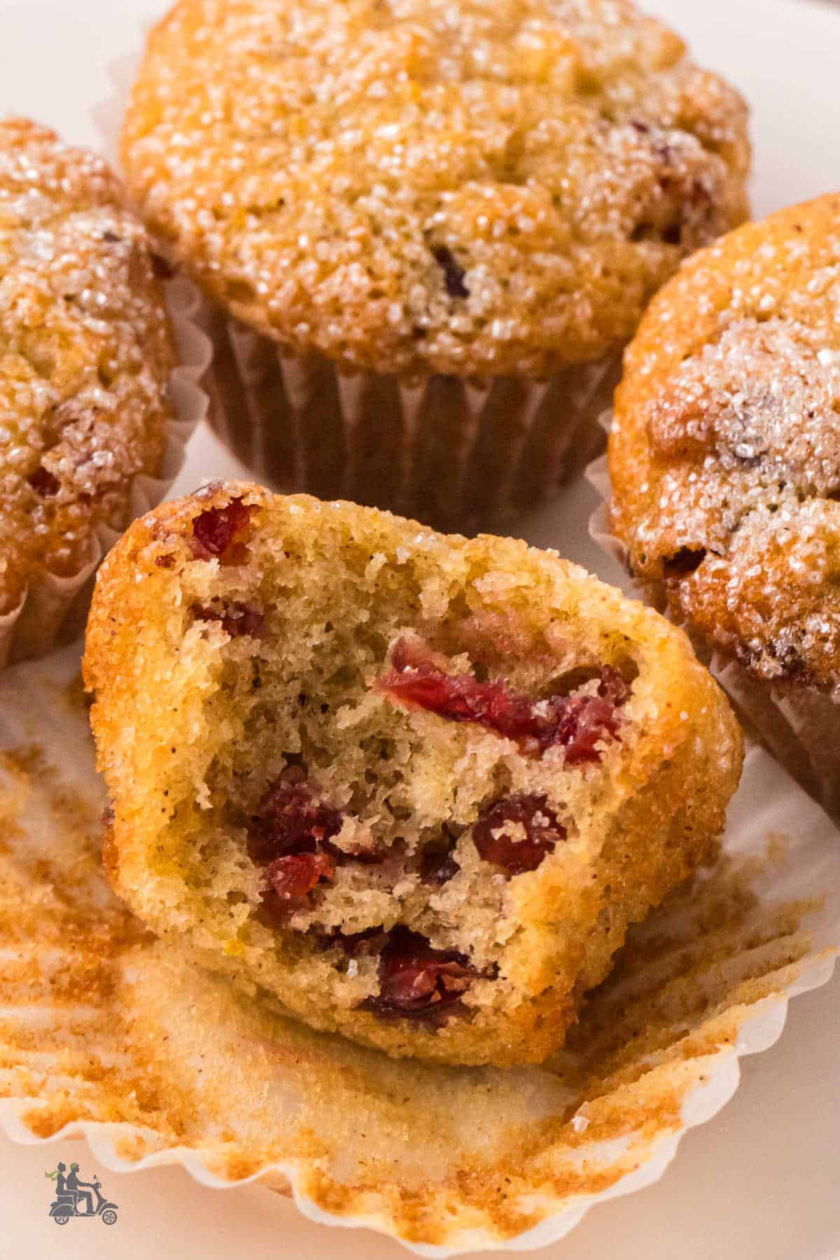Close-up of a cranberry orange muffin with the cranberries showing throughout the sweet bread.