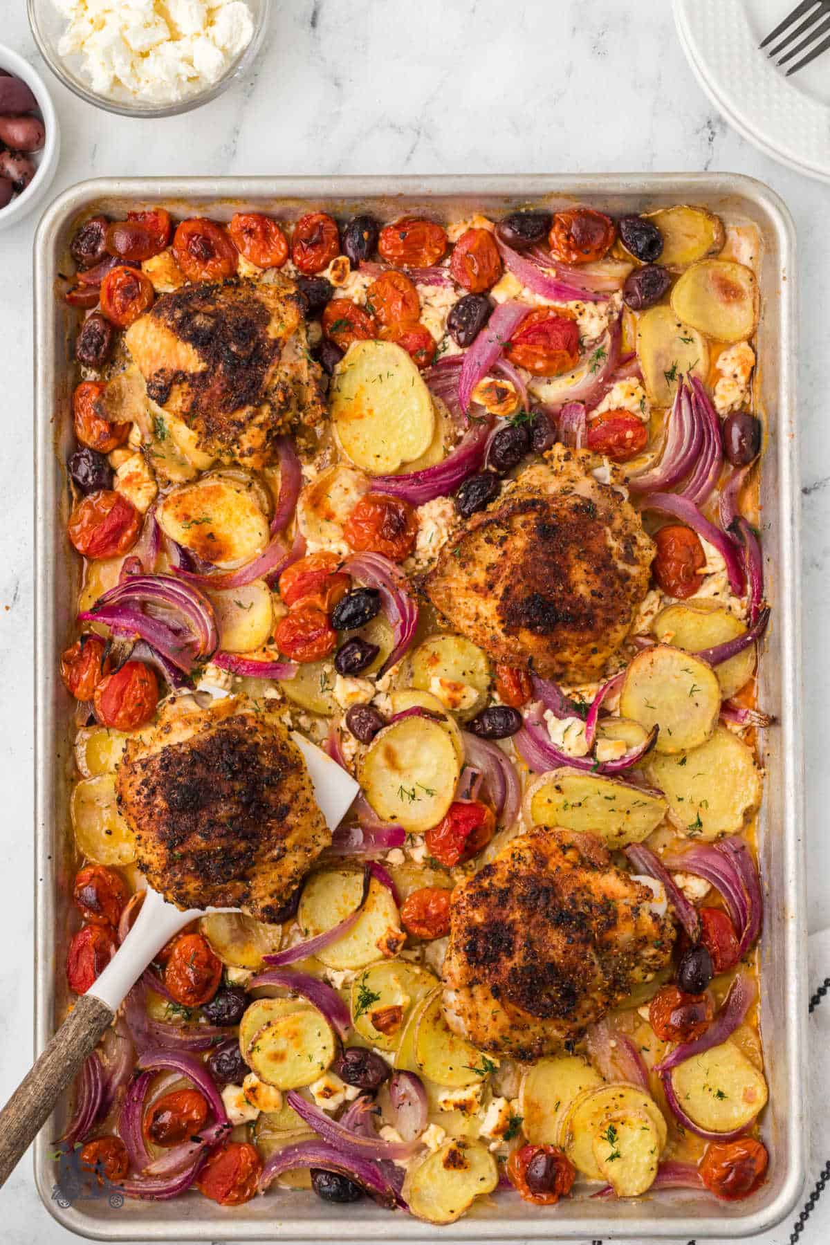 Juicy, herby, lemony Greek Chicken all in one pan with bell peppers, potatoes, and Kalamata olives. 