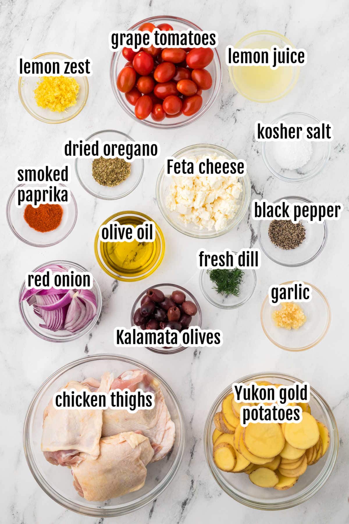 Image of the ingredients needed to make the Greek Chicken Thighs on a sheet pan with vegetables.