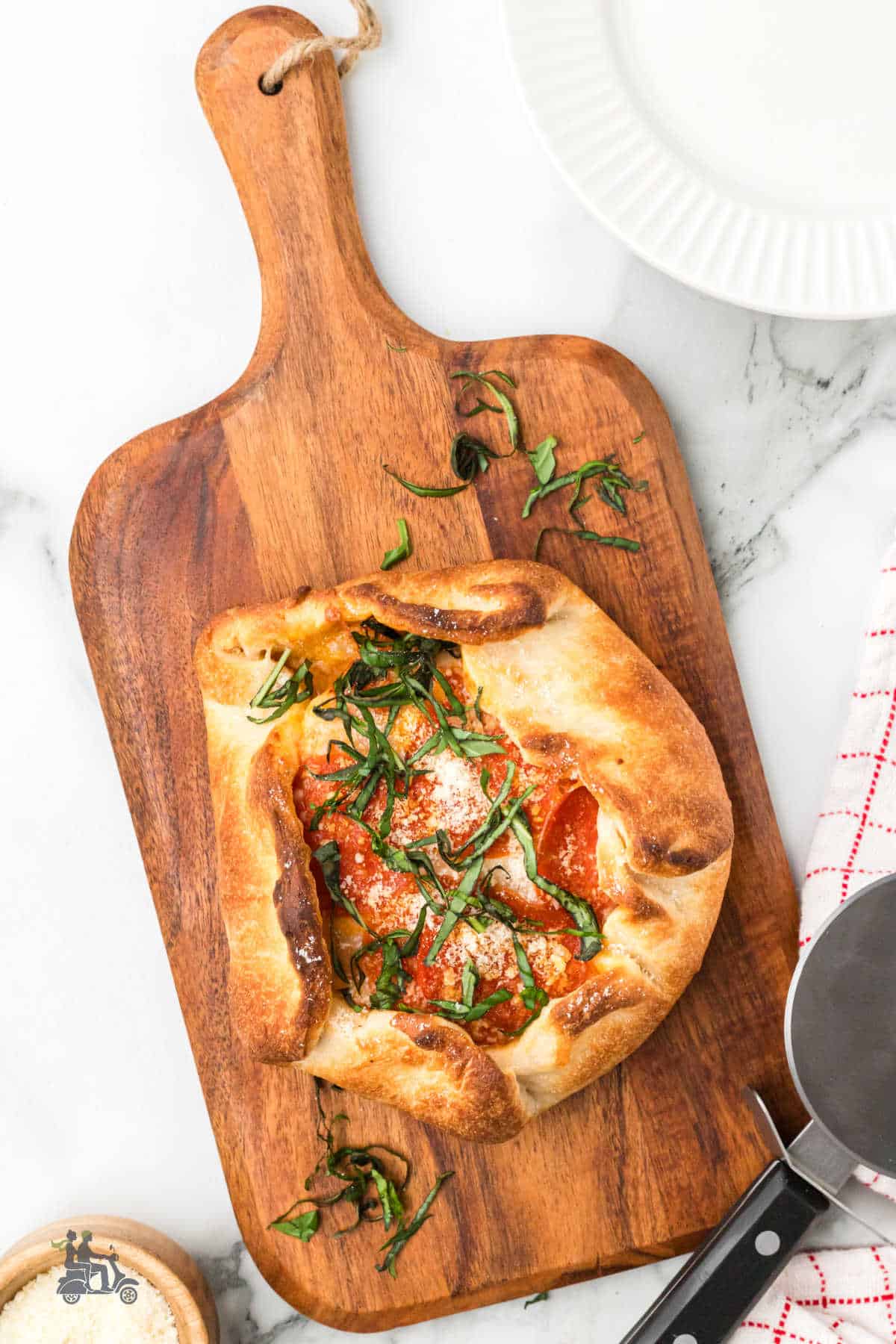 Brie Cheese Pizza topped with Pepperoni on a wooden cutting board.