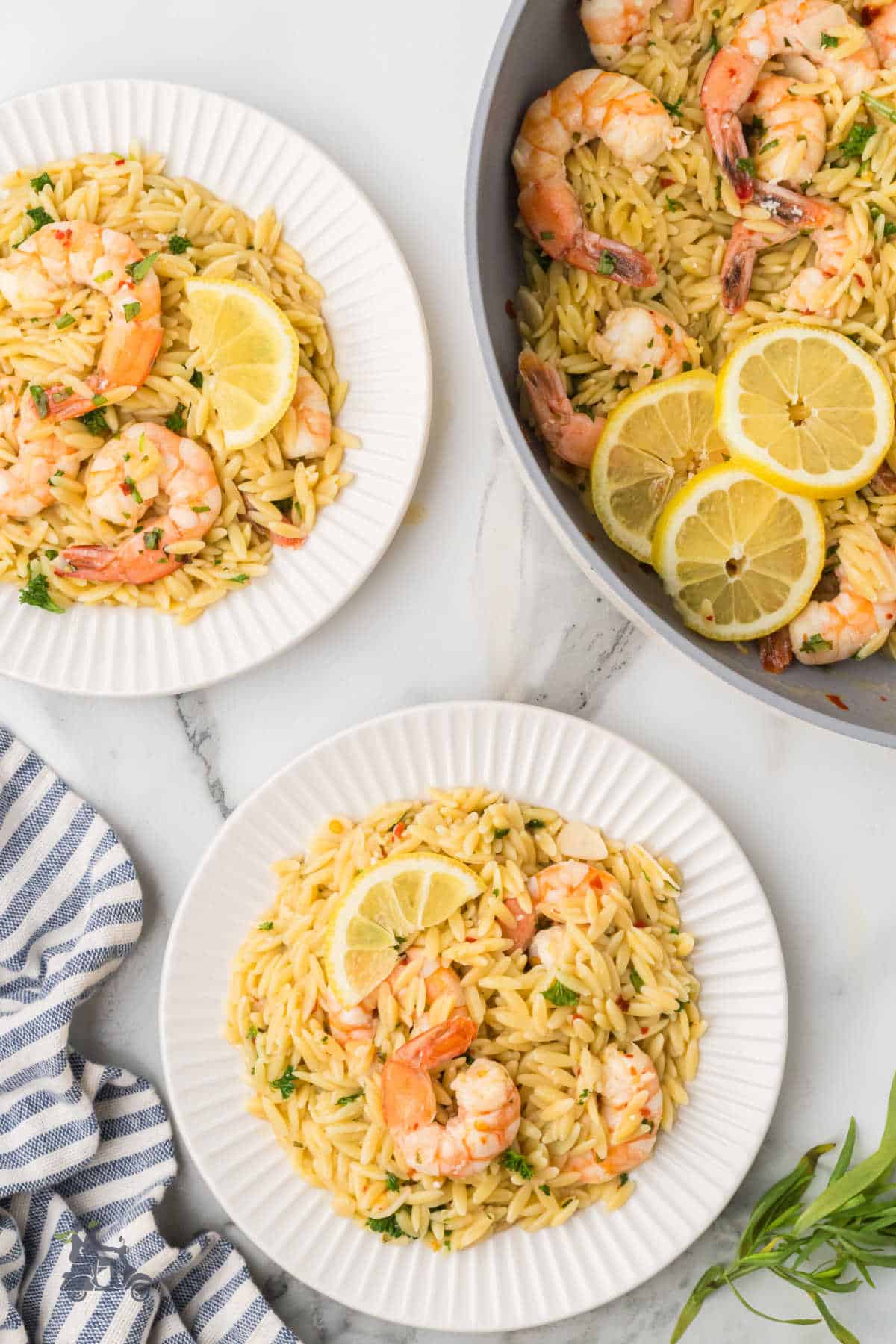 Quick and easy one-pan lemon shrimp scampi pasta, served on white plates.