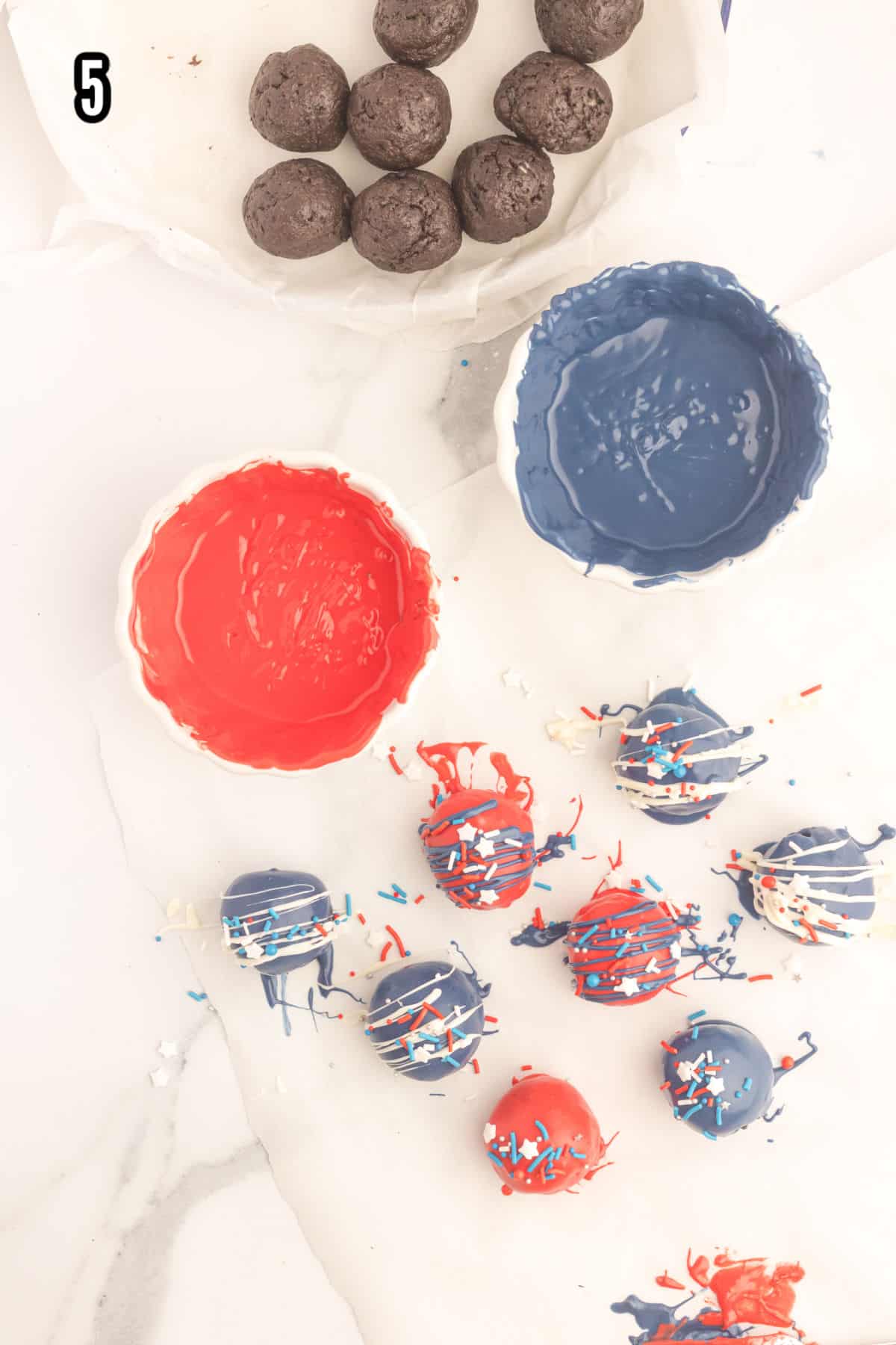 Image of the final step of the oreo balls recipe which is decorating the truffle candy in red, white, and blue.