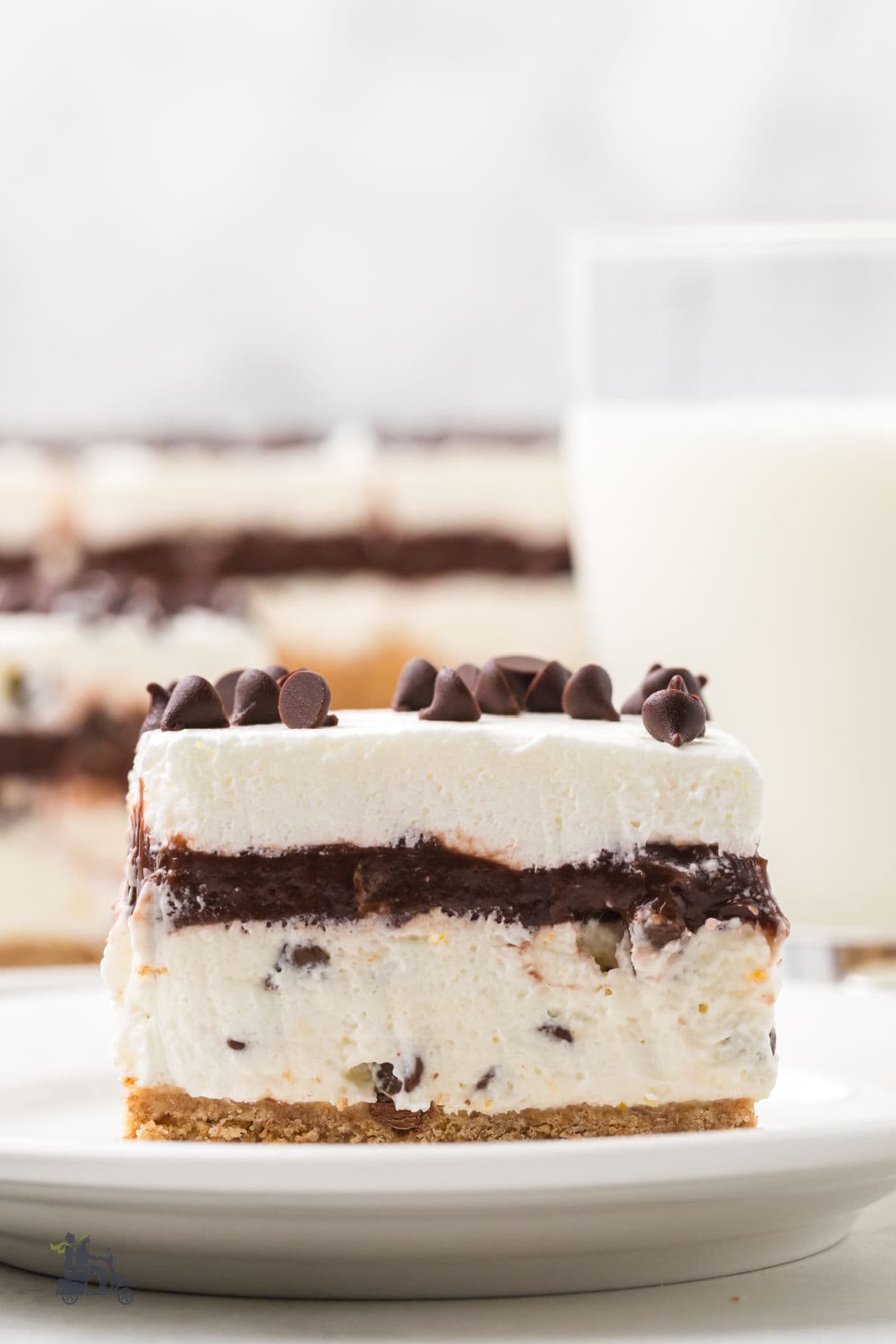 Cool, creamy cannoli-inspired chocolate lasagna served on a white plate with a glass of milk. 