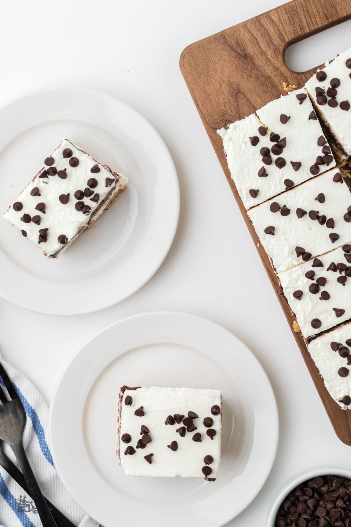 Overhead view of the cannoli-inspired chocolate no-bake dessert cut into squares and served on white plates. 