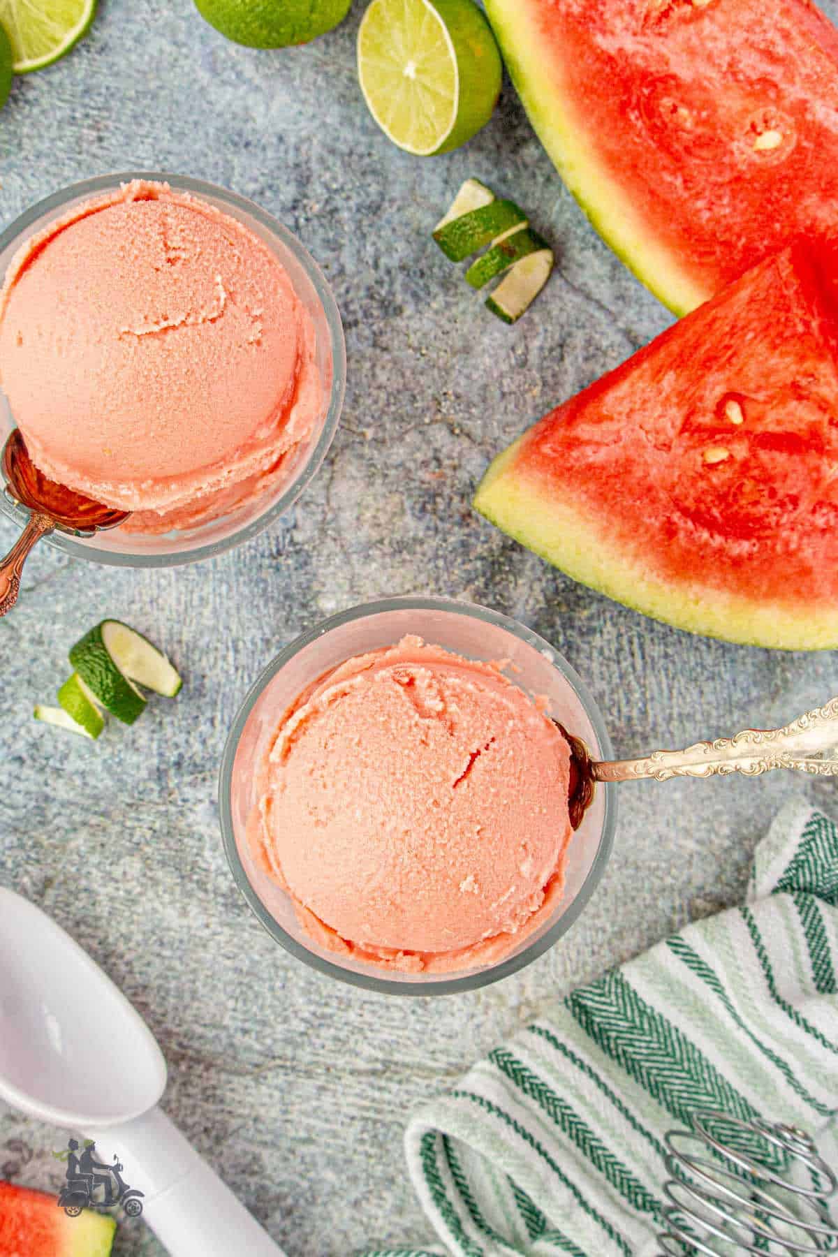 Easy watermelon ice cream is scooped into glass goblets with a spoon stuck in the frozen dessert.