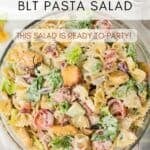 A Pinterest share button photo with a title overlay featuring an overhead view of a glass bowl filled with BLT bow tie pasta salad.