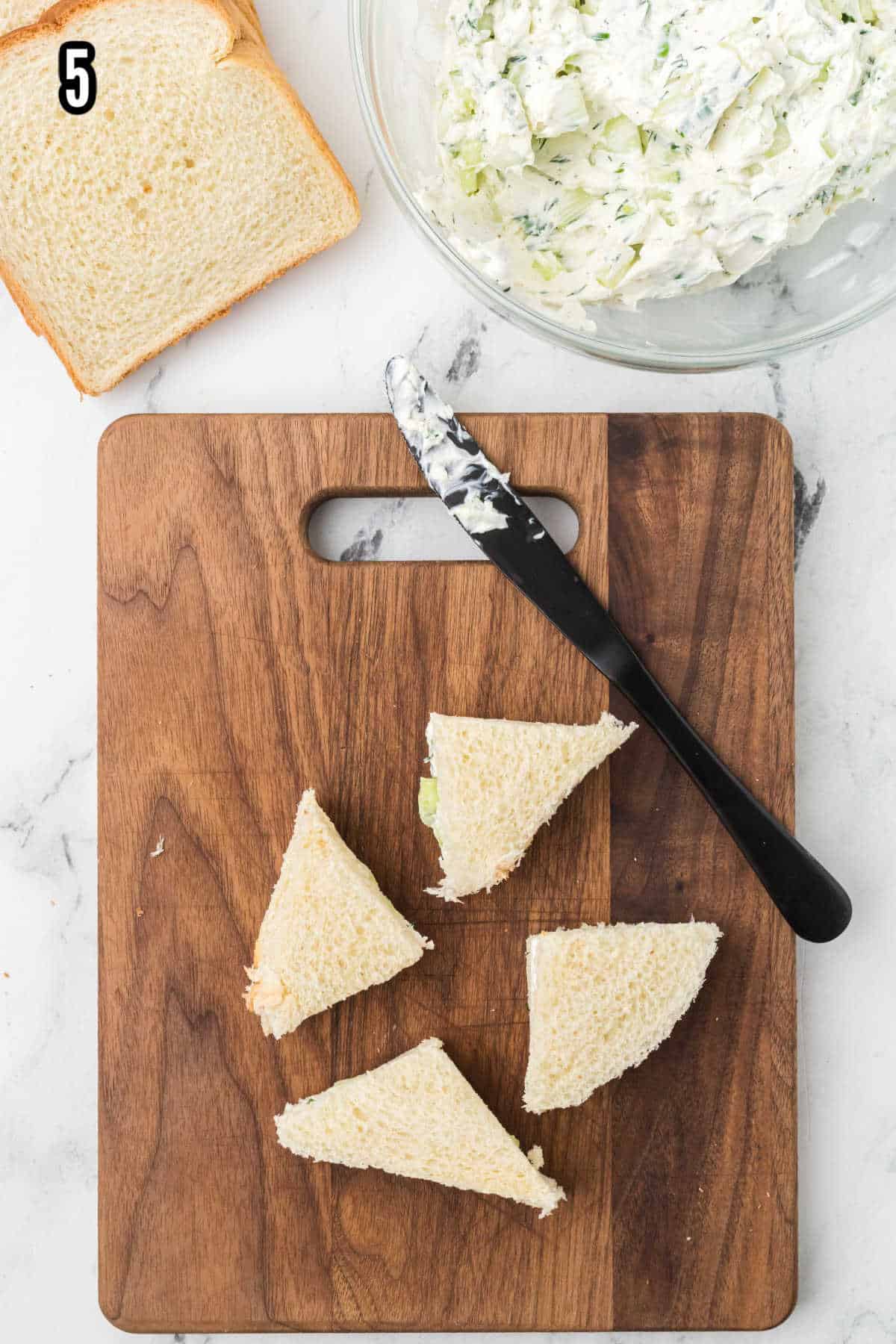 A photograph showing how to cut the cream cheese cucumber sandwiches into triangles.