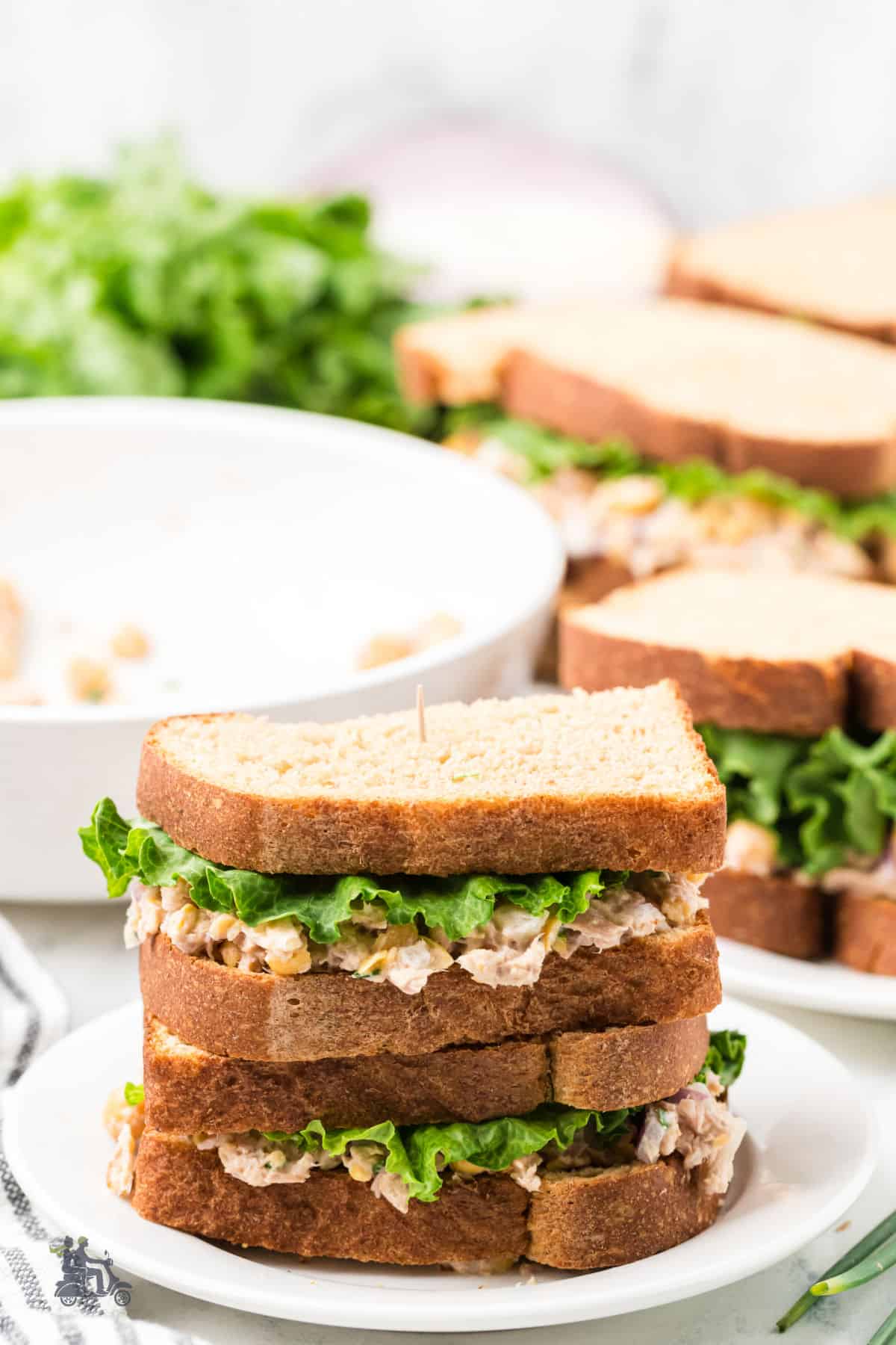 Light and healthy tuna and chickpea salad with romaine lettuce between whole wheat bread slices.