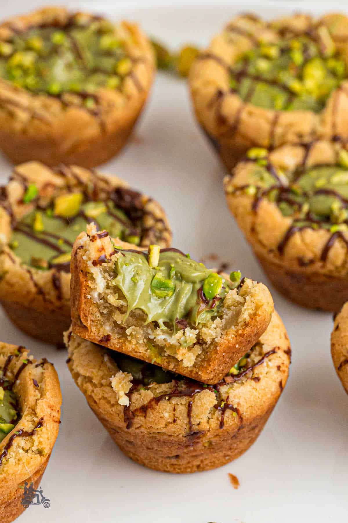 A close up of the brown butter cookies filled with pistachio cream and a bite taken out of the top cookie. 
